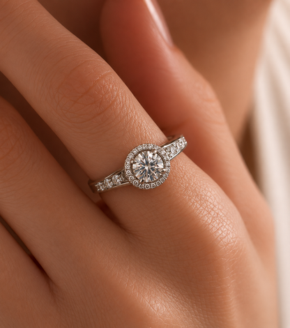Diamond ring on a person's finger with a soft focus background